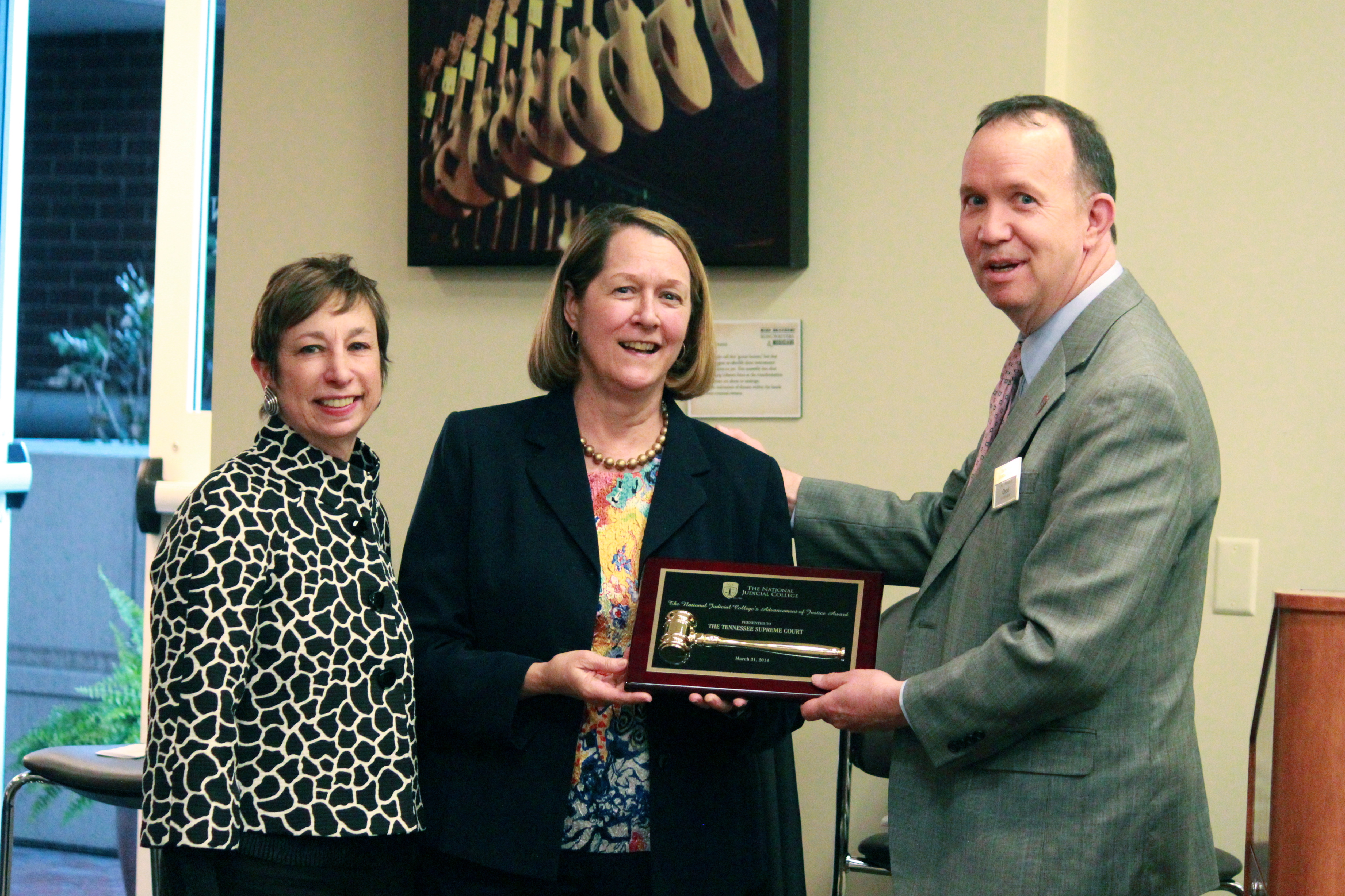 Supreme Court Justice Janice M. Holder and Justice Cornelia A. Clark receive the Advancement of Justice Award from the National Judicial College's Chad Schmucker.