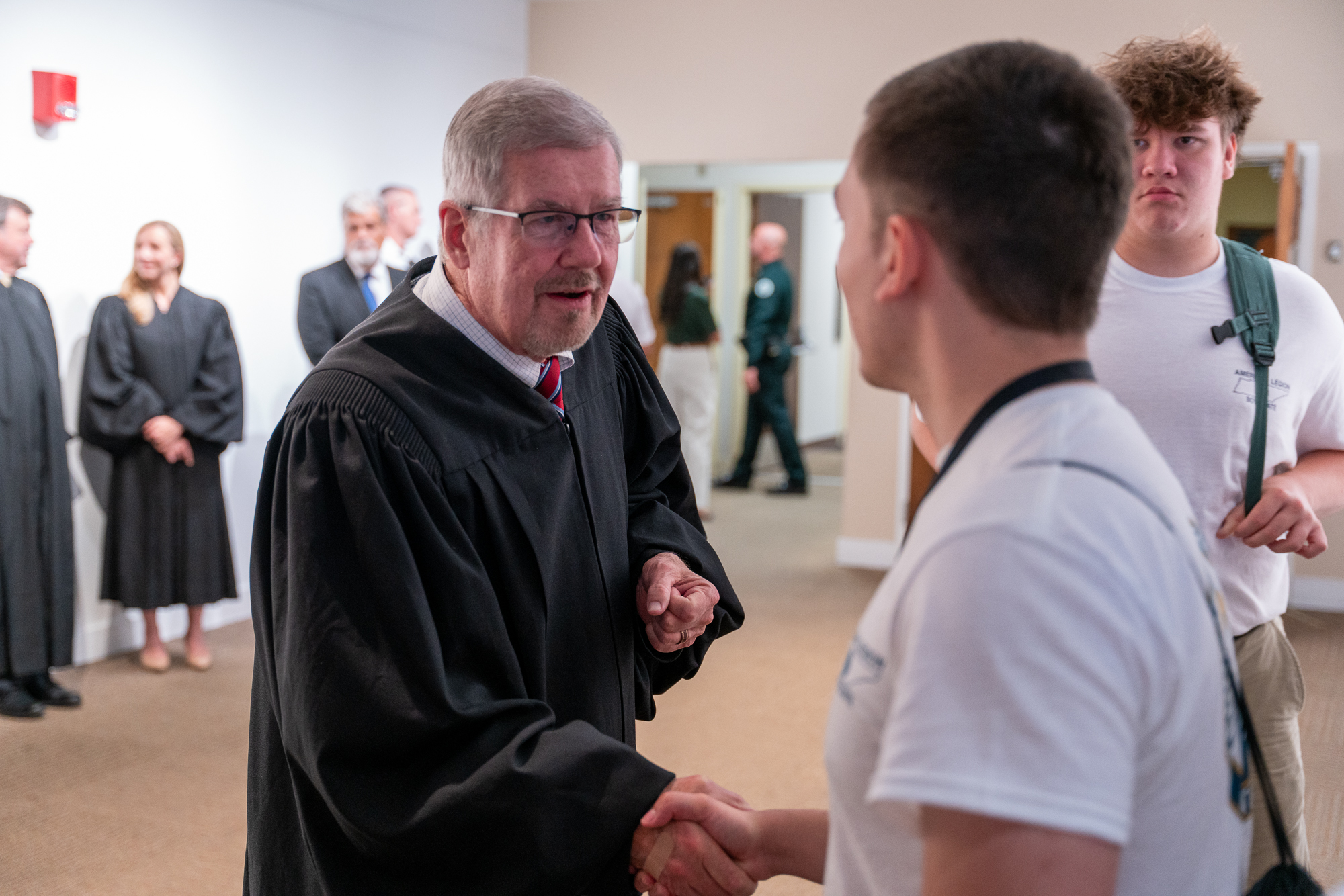 Chief Justice Jeff Bivins shakes the hand of a Boys State participant