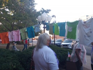 An attendee looking at the clothesline of T-shirts