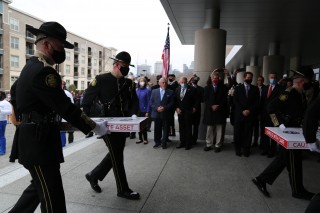 The Tennessee Highway Patrol Color Guard escorts the constitutions into the new building while the judiciary and other state officials look on.